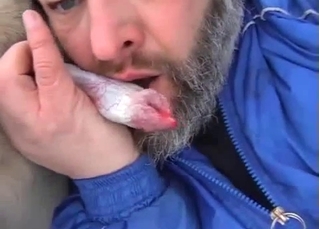 Bearded zoophile is sucking a doggy dick outdoors